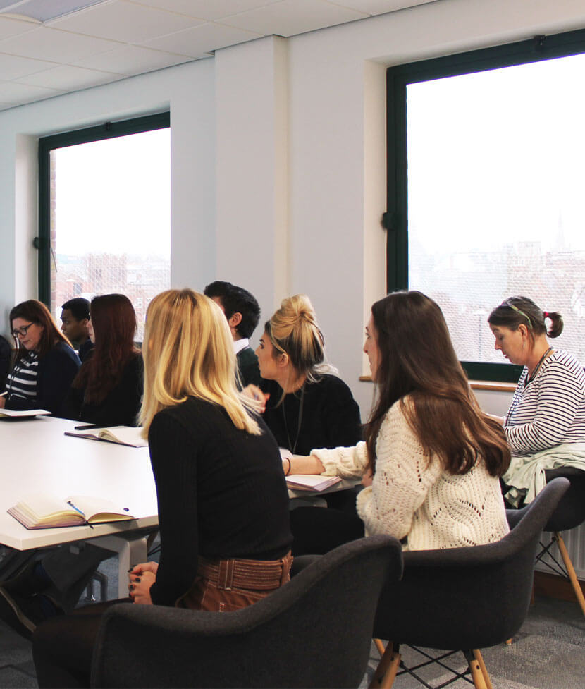 Concertus employees sitting around table taking notes in training