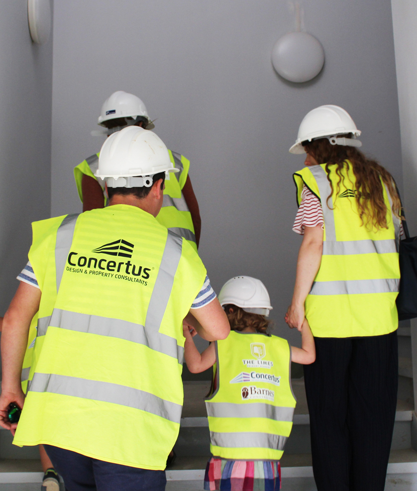 Family wearing PPE walking up stairs