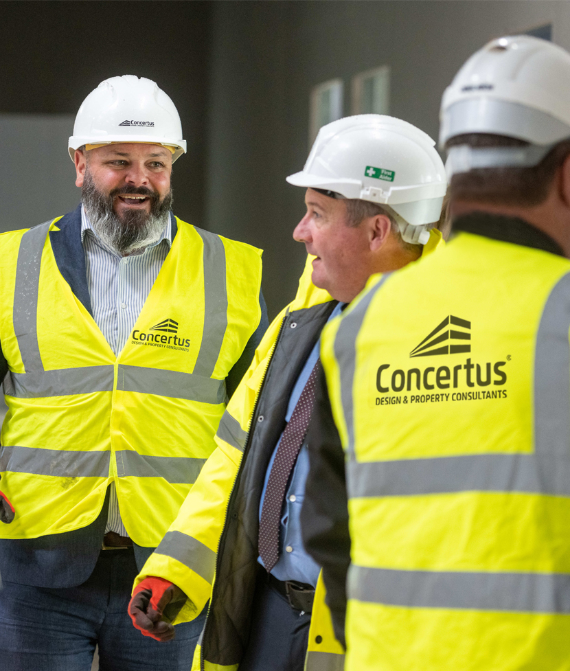 Men wearing PPE talking on building site