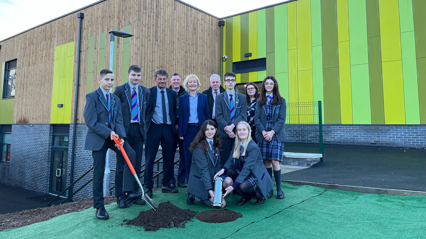 Staff and pupils burring time capsule outside Breckland school